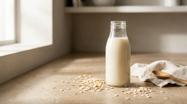 Fresh homemade oat milk in a glass bottle with rolled oats